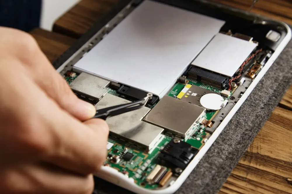 main_reconditionne_reparation_tablette_composant_visible_batterie_carte_mere
